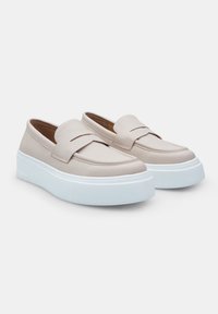 Bežīgas ādas slaidās kurpes ar noapaļotu pirkstu un zemu baltu platformas zoli. Pārklātas ar šuvu akcentu gar augšdaļu.