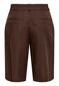 Short marron taille haute, ajusté, avec passants de ceinture et deux poches arrière passepoilées sur fond blanc.