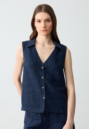 Marineblauwe mouwloze linnen top met een V-hals en een knopenlijn aan de voorkant, voorzien van houten knopen en een ontspannen pasvorm.