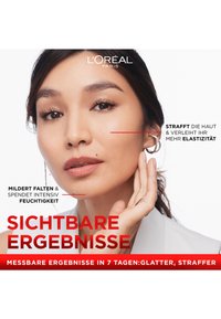 L'Oréal Paris skincare ad featuring a woman with medium skin tone, wearing a light beige top, silver hoop earrings, and a natural makeup look.