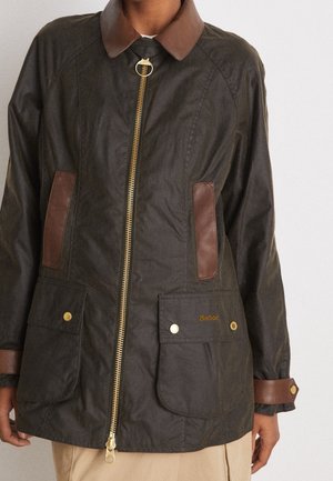 Dark green waxed jacket with brown leather collar, pockets, and cuffs, featuring a gold zipper and snap-button flap pockets.