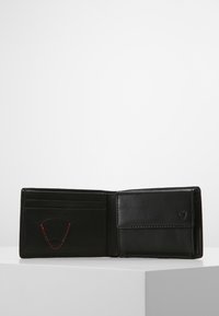 Portafoglio in pelle nera con più slot per carte, una tasca per banconote e una finitura texture. Caratterizzato da cuciture rosse e un accento con logo.