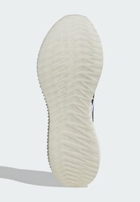 Suola della scarpa realizzata in un materiale gommoso bianco testurizzato con un motivo a zigzag per garantire aderenza e stabilità, che mette in evidenza un design flessibile.