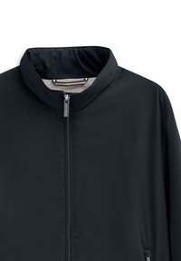 Giacca a vento nera da uomo con colletto alto, zip anteriore nascosta e tasche laterali. Tessuto liscio e materiale leggero.