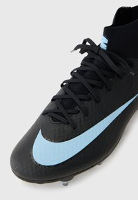 Crni nogometni kopački s textured gornjim dijelom, plavim Nike swooshom, crnim vezicama i ovratnikom poput čarape za podršku gležnju.
