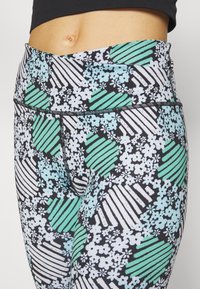 Leggings a vita alta con un motivo floreale e a righe in verde menta, bianco e nero. Tessuto elasticizzato con una texture liscia.
