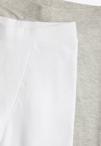 Zwei Hosenpaare: eine weiße mit gerippter Textur und eine hellgraue mit glatter, melierter Oberfläche. Beide haben einen elastischen Bund.
