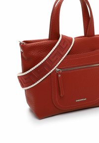Borsa tote in pelle rossa con finitura texture, dotata di doppio manico, tasca frontale con zip e tracolla decorata con un motivo, rifinita con cuciture bianche.