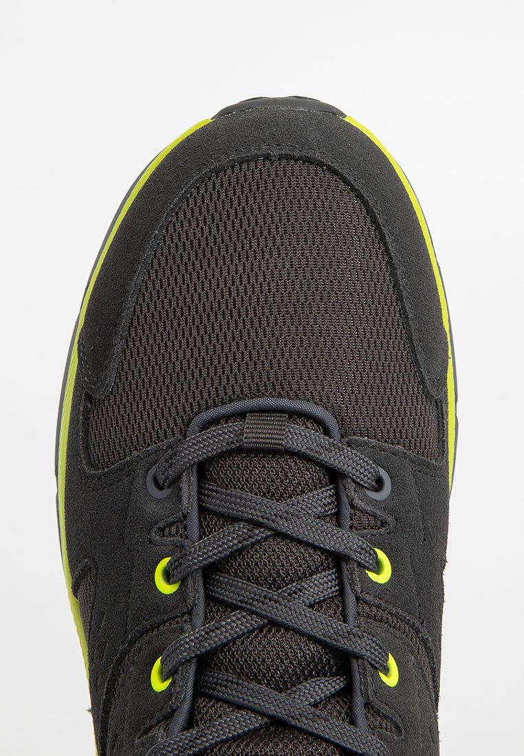 Czarne buty sportowe z siateczkową cholewką, grubymi sznurowadłami i fluorescencyjnymi żółtymi akcentami. Okrągły nosek i wyściełany kołnierz dla komfortu.