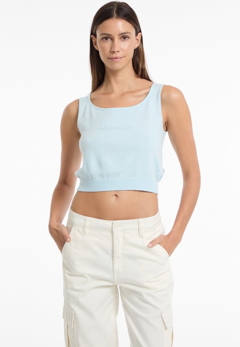 Top corto di colore blu chiaro con scollo ampio e orlo a coste. Presenta un ricamo del marchio sul fronte in un colore sobrio e abbinato.