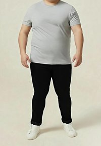 Šedé tričko s krátkými rukávy v kombinaci s černými přiléhavými kalhotami a bílými teniskami. Látka působí hladce s klasickým kulatým výstřihem.