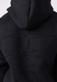 Sweat à capuche noir avec logo PXLP en relief et motif en forme d’étoile sur la partie supérieure du dos, présenté sur un fond clair uni.