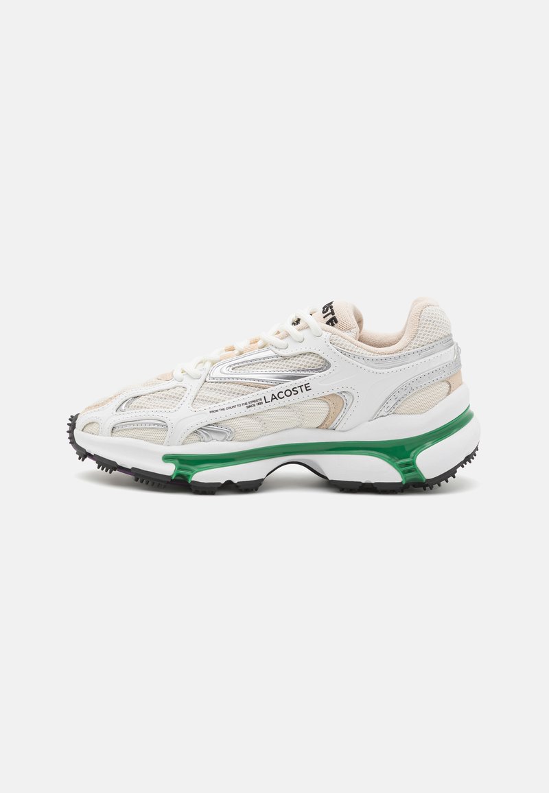 White sneaker with grey and beige mesh panels, silver accents, green midsole, and black textured rubber outsole. Features lace-up closure.