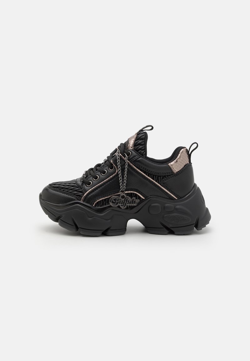 Black athletic sneaker featuring a textured upper, metallic accents, lace closure, chunky sole, and a chain detail on the side.