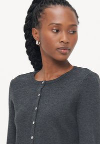 Dark gray cardigan with a round neckline and button closure. Soft texture, long sleeves, and a smooth knit finish. No patterns or accents.