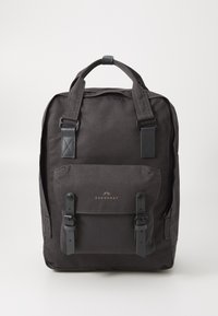 Sac à dos noir en toile avec deux bretelles ajustables, une poignée supérieure, une poche avant avec des fermetures à boucle et un détail de logo minimaliste.