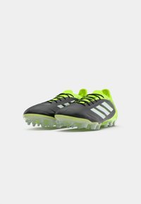 Pair of black and neon green Adidas soccer cleats with white stripes and black laces, positioned at an angle on a white background.