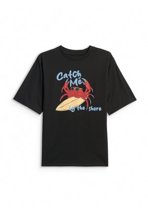 Czarny t-shirt z czerwonym krabem w okularach przeciwsłonecznych, trzymającym deskę surfingową oraz tekstem „Catch Me by the Shore” w niebieskiej czcionce.