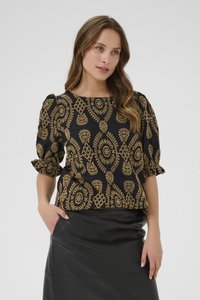 Svart topp med intrikata gyllene blommönsterbroderier, puffiga korta ärmar och rundad halsringning, i kombination med en svart läderskjol.