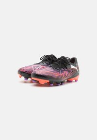 Bottines de football noires avec une tige texturée présentant des rayures en dégradé rose et violet. Comprend des lacets noirs et des crampons en caoutchouc colorés.