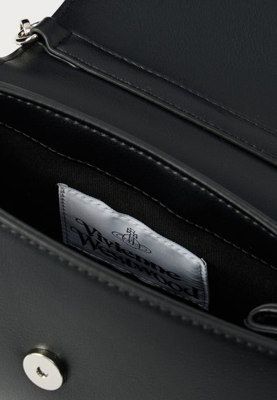 Εσωτερικό μαύρης δερμάτινης τσάντας με ασημί εξαρτήματα. Διαθέτει υφασμάτινη ετικέτα με το λογότυπο "Vivienne Westwood". Ομαλή υφή με ραμμένα άκρα.