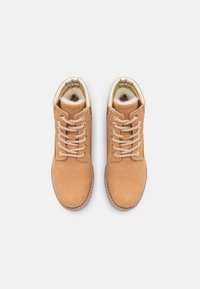 Stivali alla caviglia in suede tan con punta arrotondata, occhielli in metallo e lacci beige. Fodera interna in pelliccia sintetica beige. Dettaglio della suola cucita visibile.