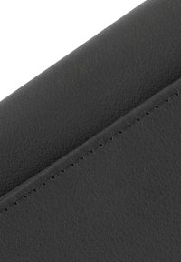 Angolo di portafoglio in pelle nera con superficie testurizzata e cuciture visibili lungo il bordo. Design conciso e angolare.