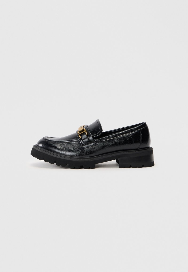 Loafer din piele neagră, cu toc bloc mic, prezentând un accent din metal auriu și un superior texturat. Talpa din cauciuc Dick, cu model.
