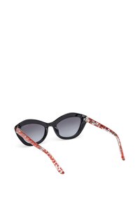 Gafas de sol estilo cat-eye en color negro con lentes graduados en gris, que cuentan con patillas con un patrón rojo y transparente. El material parece brillante y tiene una textura suave.