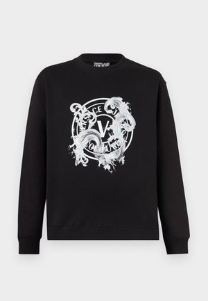 Fekete kerek nyakú pulóver fehér, díszes, kerek Versace Jeans Couture logóval a közepén elöl.