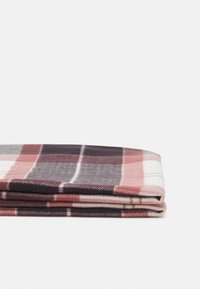 Écharpe en laine à carreaux avec des rayures rouges, blanches et bleu marine. Texture douce avec un design plié, mettant en valeur des couleurs et des motifs alternés.