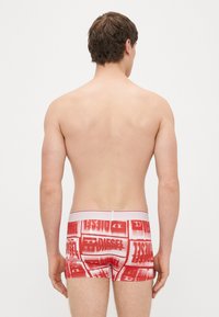 Boxer briefs rossi con un audace motivo di logo bianco, vita elastica con accenti rossi, realizzati in tessuto elasticizzato, aderiscono perfettamente alla vita.