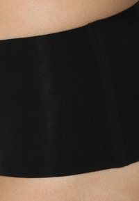 Ceinture en tissu noir, texture lisse, matériau élastique, design slim, intégration sans couture, adaptée pour le port sous des vêtements.