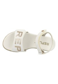 Witte sandaal met een brede band met "REP" in glinsterende gouden letters en een enkelbandje dat is vastgemaakt met een metalen knoop. Soepele zool.