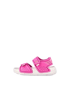 Sandalia rosa ajustable para niños con tiras perforadas y suela blanca acolchada con motas rosas, vista lateral sobre fondo blanco.