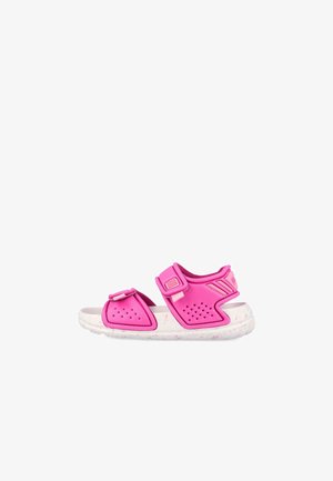 Sandalia rosa ajustable para niños con tiras perforadas y suela blanca acolchada con motas rosas, vista lateral sobre fondo blanco.