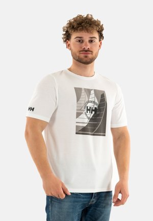 Camiseta de algodón blanca con un estampado gráfico en escala de grises, con formas geométricas y un logo circular en el lado izquierdo del pecho.