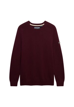 Suéter burdeos de punto con cuello redondo y mangas largas, puños y dobladillo acanalados, etiqueta de la marca Superdry en el cuello y pequeño parche en la manga izquierda.