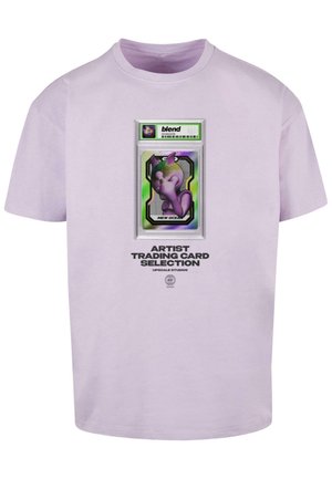 T-shirt di cotone lilla con grafica di una falsa carta da gioco, un personaggio stilizzato, testo in basso e dettagli del logo.