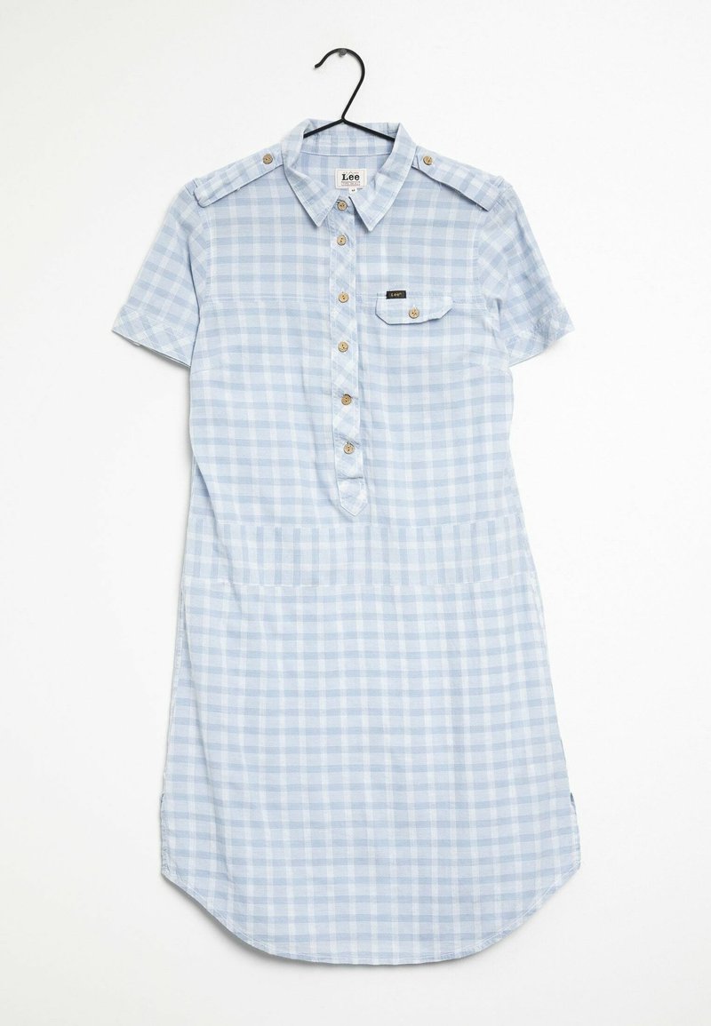 Robe chemise à manches courtes à carreaux bleu clair et blanc, avec boutons sur le devant, poche poitrine et bretelles à boutons, suspendue sur un cintre noir.