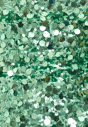 Tissu en sequins verts avec des sequins circulaires réfléchissants de différentes tailles, densément disposés sur un support, créant une surface texturée et scintillante.