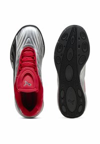 Baskets de sport argentées avec un intérieur rouge, dessus texturé et semelle extérieure noire ornée de motifs circulaires. Logo PUMA sur la languette.