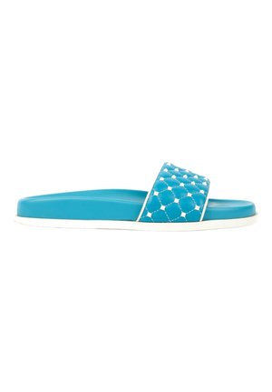 Sandale slide bleue avec semelle blanche et une bride texturée présentant un motif hexagonal matelassé.