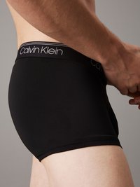 Fekete pamut boxer alsónadrág, testhez álló kialakítással. Az öv részén egy kontrasztos szürke "Calvin Klein" logó található. Sima felület.