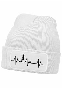 White knit beanie with a ribbed texture, featuring a patch with a black running figure and heartbeat line graphic on the front.
