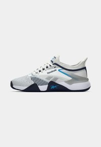 Adidași albi și bleumarin, cu un superior din plasă respirabilă, model texturat, talpă cu amortizare și accente albastre, purtând marca Reebok.