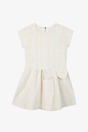 Kremowa sukienka z krótkimi rękawami, teksturowany materiał, rozkloszowany fason i kokarda w talii. Zamek błyskawiczny z tyłu.