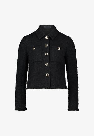 Black tweed jacket with a cropped cut, button closure, two chest pockets, and metallic buttons. Frayed hem and textured fabric detail.