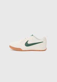 Nike sko med kremfarget lær øvre del, grønn swoosh, har pustende meshpaneler og en såle i gummi for godt grep.