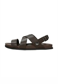 Braune synthetische Rutschen-Sandalen mit Kreuzriemen, einem hinteren Schnallenverschluss zur Anpassung und einer flachen schwarzen Gummisohle. Glatte Textur und minimalistisches Design.